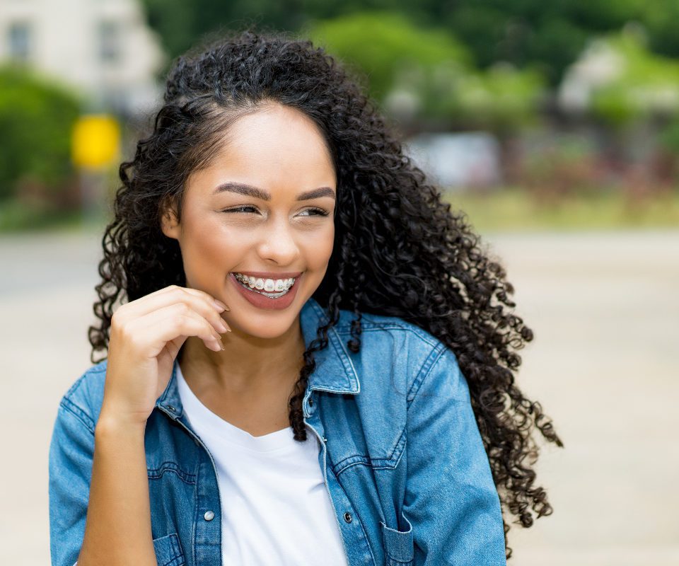 young woman with braces smiling outside